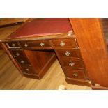 AN EDWARDIAN OAK PEDESTAL DESK, with three drawers to each pedestal and two short and one long to