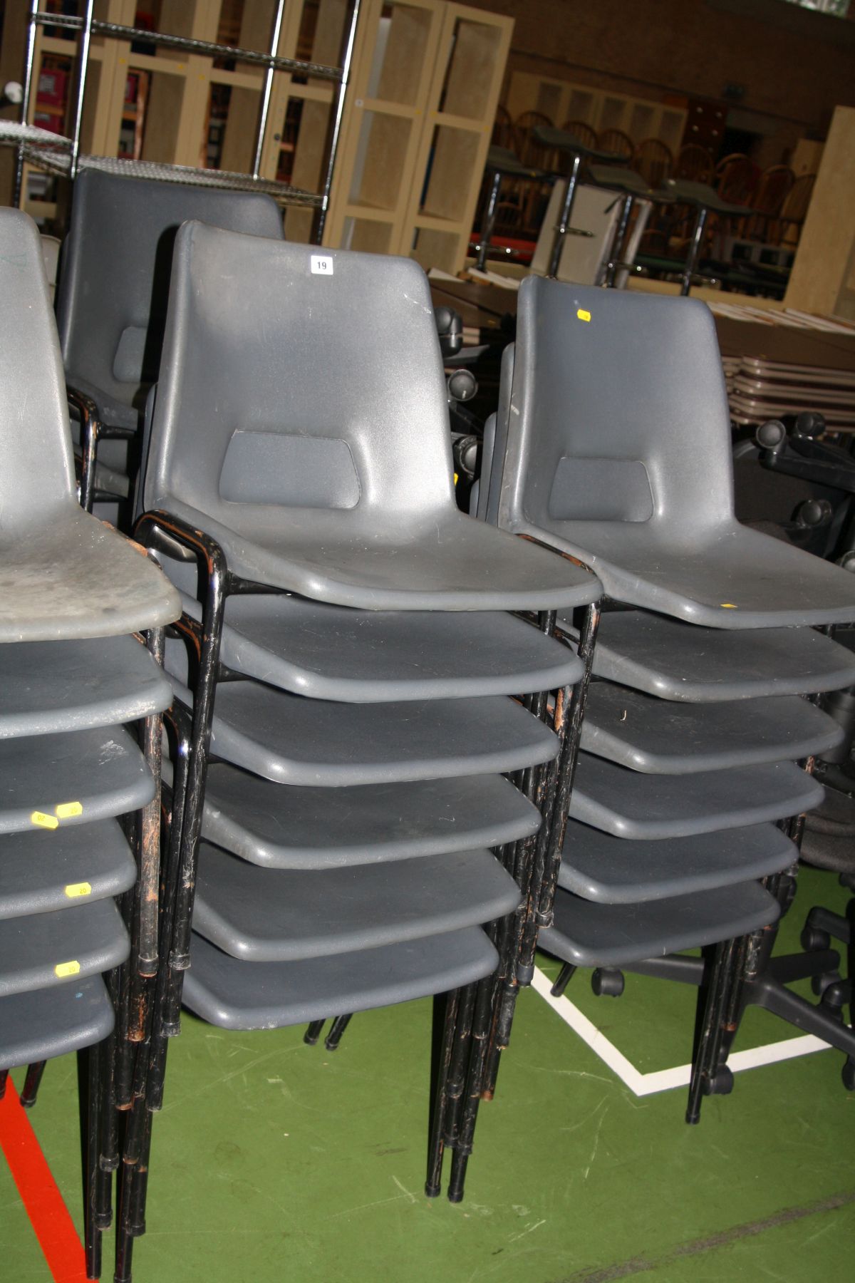 EIGHTEEN GREY PLASTIC STACKING CHAIRS, with black tubular metal legs (s.d)