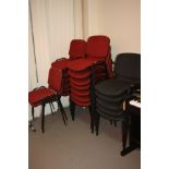 TWENTY ONE STACKING OFFICE CHAIRS, with red or grey fabric upholstery on a metal frame