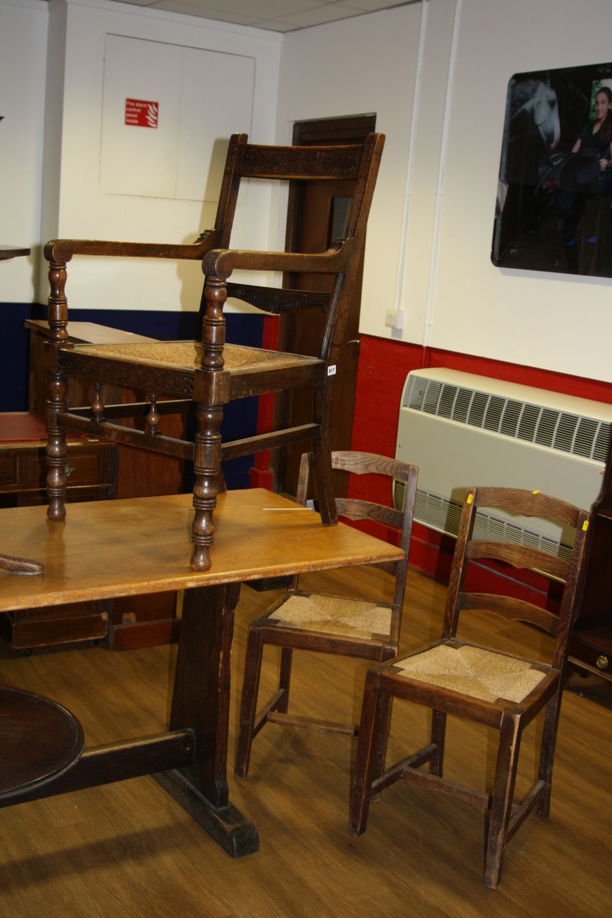 AN EARLY 20TH CENTURY OAK ELBOW CHAIR, with rush seating and carved back rails and two rush seated