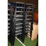 EIGHTEEN STACKING CLASSROOM STOOLS, with grey plastic shaped seats on a black tubular metal base