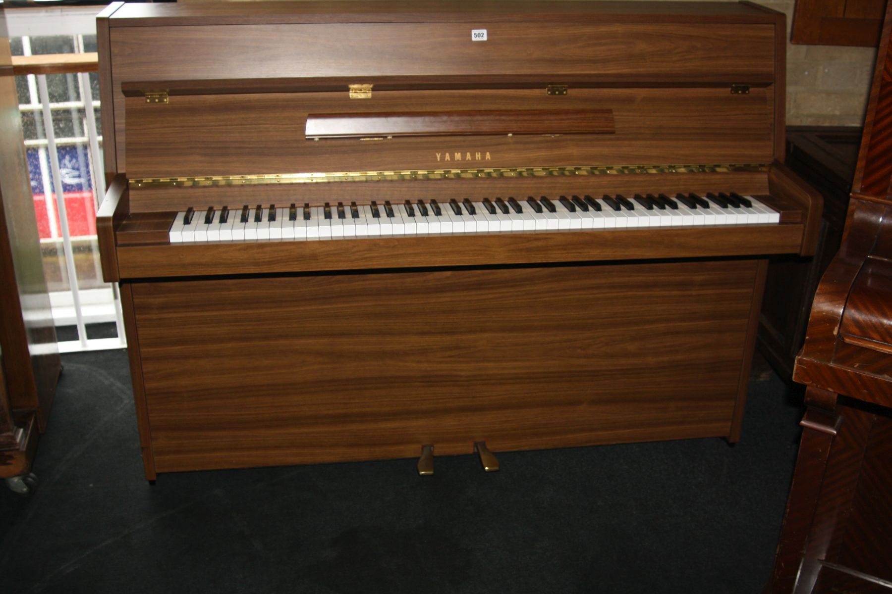 A YAMAHA E108 UPRIGHT PIANO, with a walnut case Serial No. 5880196 148x108cm high