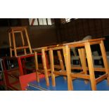 FOUR MODERN BEECHWOOD LABORATORY STOOLS, with hand hold in centre of the seat, 51cm high (s.d)