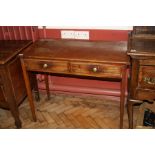 AN EDWARDIAN MAHOGANY TWO DRAWER SIDE TABLE, standing on tapered square section legs and brass round