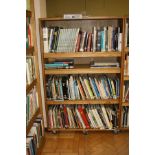 AN OAK VENEERED DOUBLE SIDED ROLLING BOOKCASE, with eight adjustable shelves and wheels,