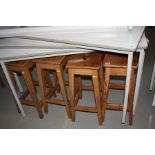 FOUR WOODEN STOOLS WITH RECTANGULAR TOPS, with hand hold cut away in centre of seat, heights 61.