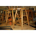 FOUR VARIOUS WOODEN STOOLS WITH OVAL TOPS, one damaged, heights 58cm to 60.5cm (4)