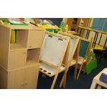 THREE CHILDS EASELS, TWO BOOKCASES AND TWO SMALL CUPBOARDS, including some pre school books, etc