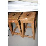 TWO WOODEN STOOLS WITH RECTANGULAR TOPS, each with a hand hold to the centre of the seat, height