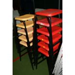 ELEVEN STACKING CLASSROOM STOOLS, with red and yellow plastic shaped seats on a black tubular