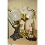 THREE TABLE LAMPS, including a brass twin burner oil lamp having milk glass shade measuring 63cm