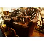 A PAIR OF CHOCOLATE BUTTONED LEATHER TUB CHAIRS on casters, together with a similar stool (3)