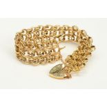 A 9CT GOLD BRACELET, designed as three rows of interlocking circular double links, to the heart