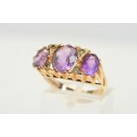 A 9CT GOLD AMETHYST AND DIAMOND RING, designed as three graduated oval amethysts interspaced by four