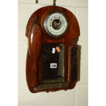 AN EDWARDIAN OAK WALL MIRROR, with an aneroid barometer and three brushes