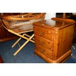 A DUCAL PINE BEDSIDE CHEST OF THREE DRAWERS together with a modern wicker moses basket (2)