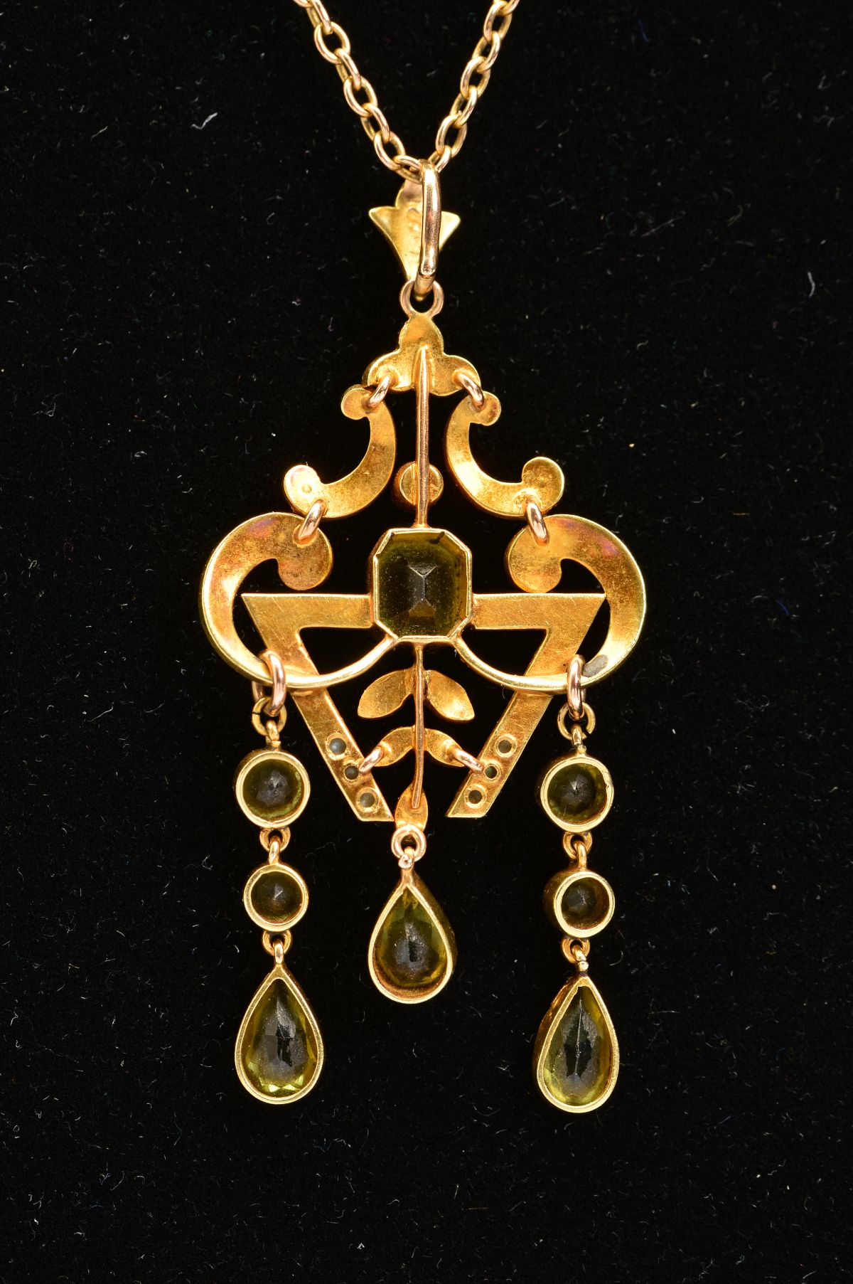 AN EARLY 20TH CENTURY PERIDOT AND SEED PEARL PENDANT, a fancy open scroll work design, suspending - Image 4 of 4