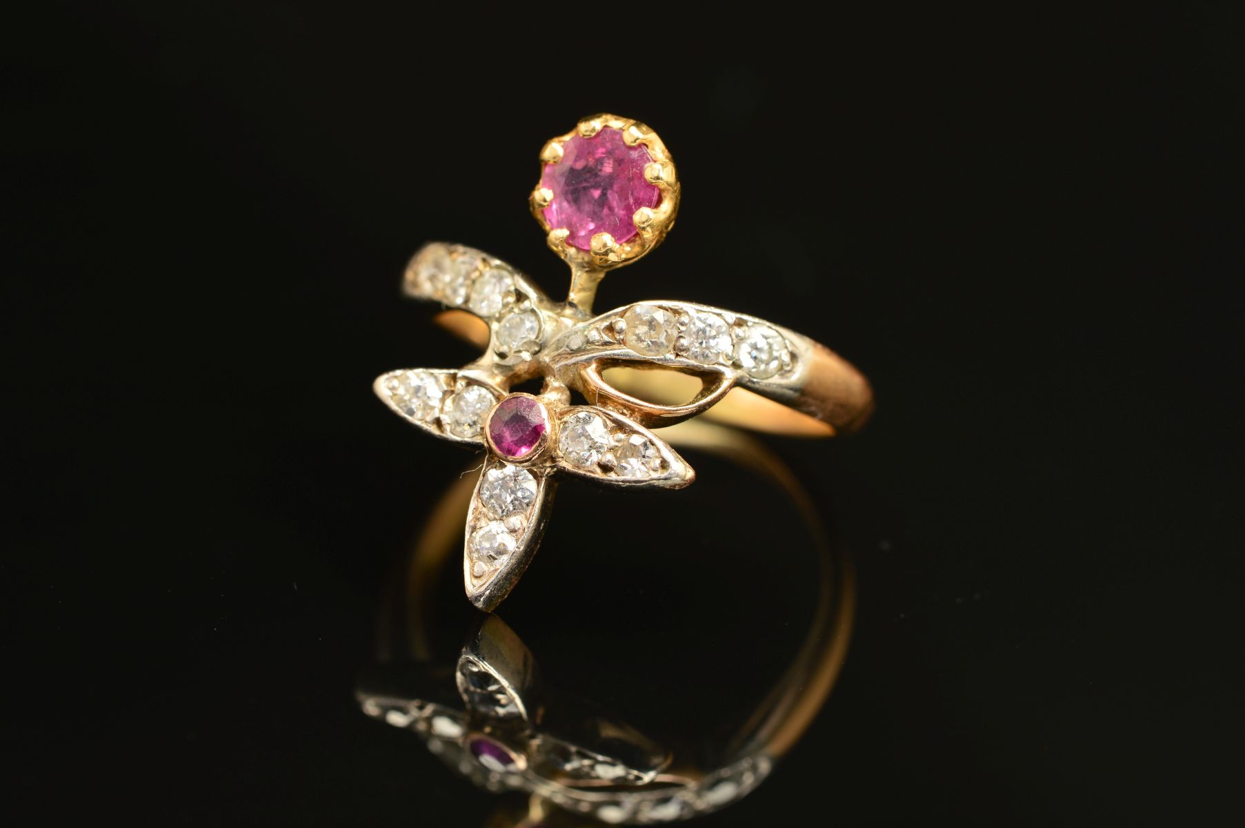 AN EARLY 20TH CENTURY RUBY AND DIAMOND FANCY ABSTRACT RING, a wishbone form supporting foliate