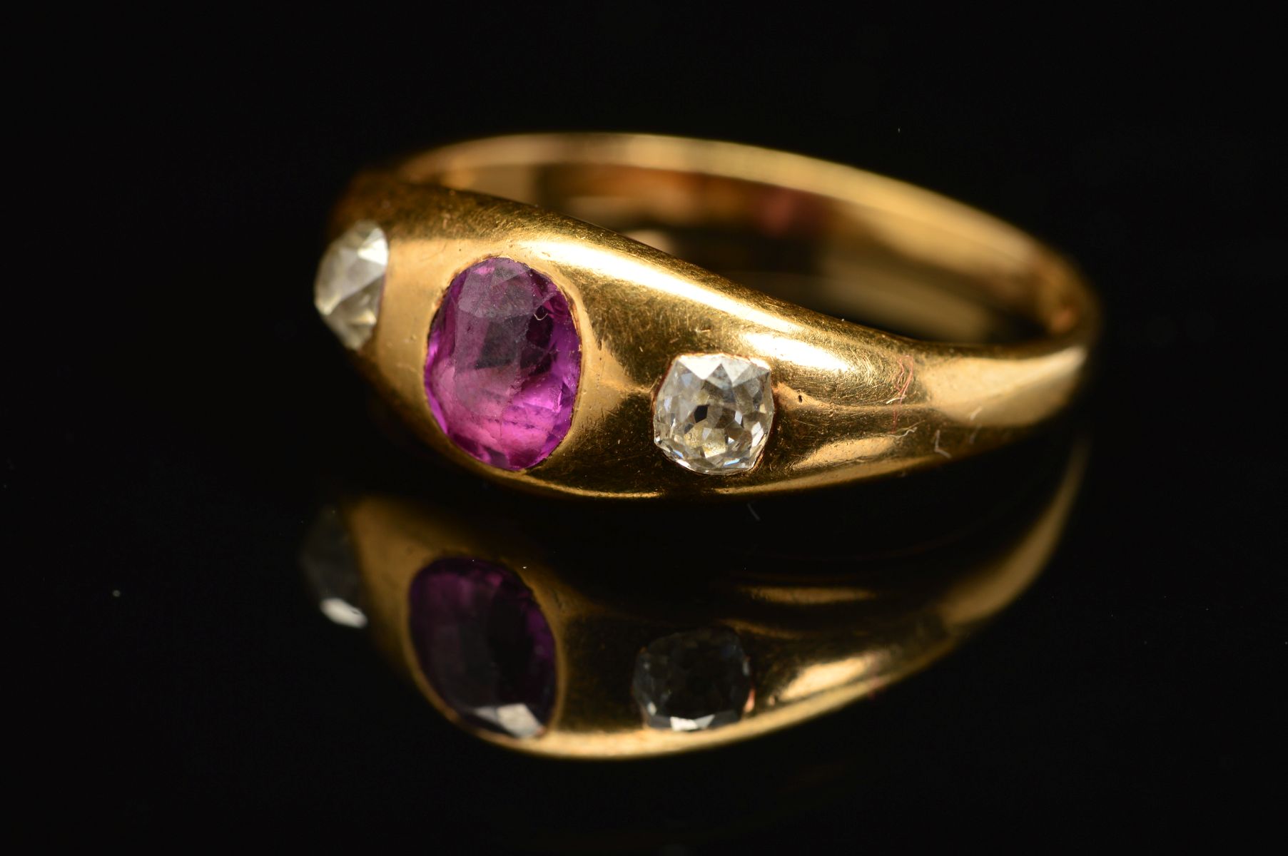 A VICTORIAN GOLD, RUBY AND DIAMOND THREE STONE RING, an oval mixed cut ruby measuring