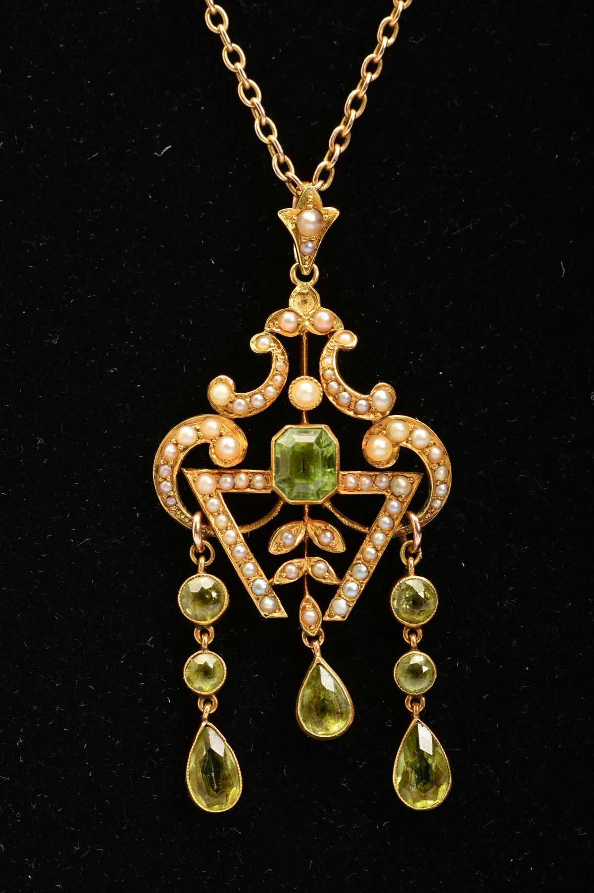 AN EARLY 20TH CENTURY PERIDOT AND SEED PEARL PENDANT, a fancy open scroll work design, suspending - Image 3 of 4