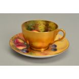 A ROYAL WORCESTER FRUIT STUDY TEACUP AND SAUCER, the exterior of the cup gilded, the interior