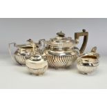 AN EDWARDIAN SILVER THREE PIECE TEA SERVICE, of part reeded oval form, with gadrooned rims, teapot