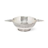 An Arts & Crafts silver quaich, first quarter 20th century, with twin pierced handles, the planished