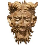 A large Italian carved wood mask of Pan, 18/19th century, with short curving horns, down cast eyes