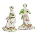 A pair of English porcelain figures of a seated boy and girl, 18th century, he wearing a pale