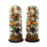 A pair of fabric, porcelain, plastic and foil flower arrangements under glass domes, Victorian