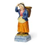 A Portobello pottery figure of a fisher woman, Rathbones period circa 1830, modelled with a creel of