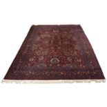 An Isfahan design carpet, mid/late 20th century, with all over design in a wine coloured field,