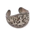 A silver cuff bracelet with warrior, Myanmar, early 20th century, the band widening to centre and