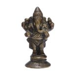 A small standing bronze figure of Ganesha, on a circular base, 19th century, 6.5cm. high Provenance: