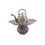 A silver teapot on a matching basin, India, 19th-20th century, the teapot of lobed form and with