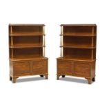 A pair of Regency style walnut bookcase cabinets, 20th century, the galleried top above three