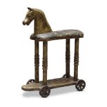 A child's hobby horse, late 19th century, with a leather covered seat, on four reel turned