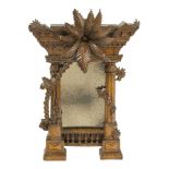 An Italian carved walnut mirror modelled as a classical ruin, 19th century, the rectangular plate