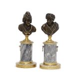 A pair of French bronze busts of Voltaire and Rousseau, late 18th/early 19th century, each on a