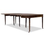 A George IV mahogany folding and extending dining table, with rounded rectangular top, having four