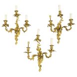 A set of six Louis XV style bronze three light wall appliques, 20th century, with acanthus leaf