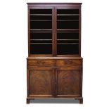 A George III mahogany bookcase, the moulded cornice above two glazed doors, enclosing three shelves,