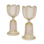 A pair of Bohemian cut and gilt glass urns on stands, late 19th/early 20th century, the cup form