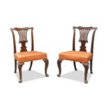 A pair of George II mahogany dining chairs, possibly Irish, with scroll carved top rails, above