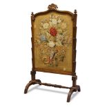 A William IV rosewood fire screen, the serpentine top rail, centred by carved acanthus decoration,