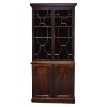 A George III mahogany bookcase, the moulded cornice above two astragal glazed doors, enclosing three