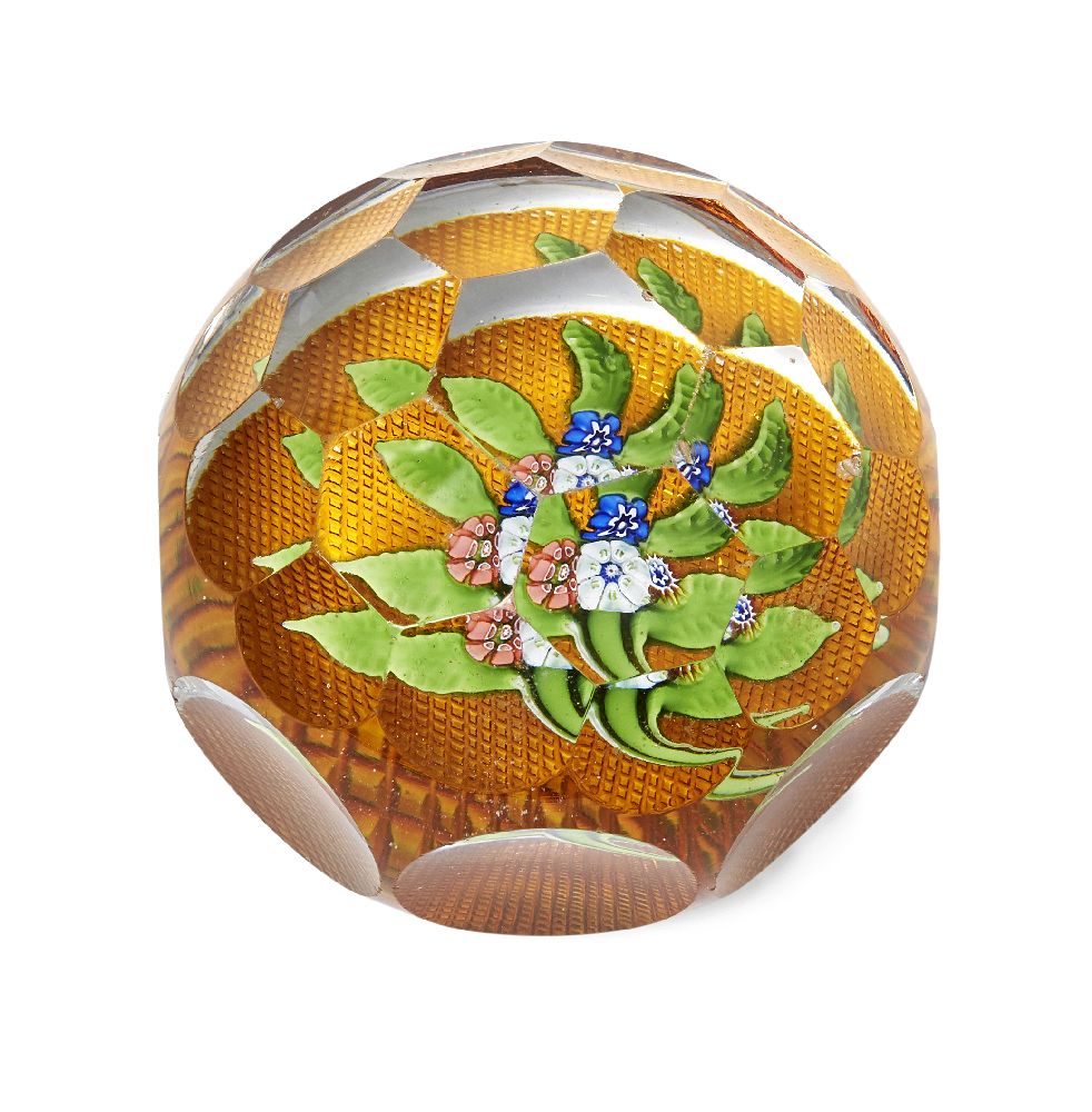 A French glass paperweight, in the style of Baccarat, with an octagonal indented body and facetted