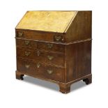 A George II walnut bureau, the fall enclosing burgundy leather inset writing surface and an