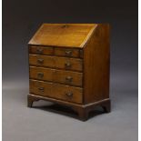 An oak bureau, early 20th Century, the fall enclosing an arrangement of pigeon holes and drawers,