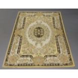 Two crewelwork carpets, mid-20th century, each decorated with a central floral panel on a ruby and